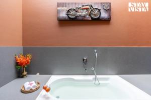 a bathroom with a sink and a picture of a motorcycle at StayVista at Terracotta Skies with Courtyard & Pool in Nashik