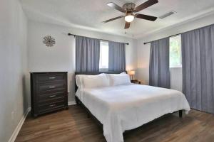 サラソタにあるFenced in With Jacuzzi Close to Siesta Key Bridge!のベッドルーム(白いベッド1台、天井ファン付)