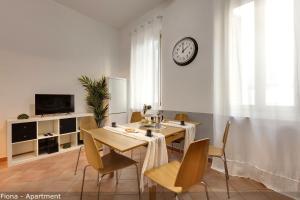 a dining room with a table and chairs and a clock on the wall at Mamo Florence - Fiesolana Apartments in Florence