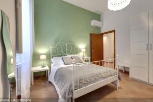 a bedroom with a bed and a green wall at Mamo Florence - Fiesolana Apartments in Florence