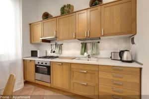 a kitchen with wooden cabinets and a sink at Mamo Florence - Fiesolana Apartments in Florence