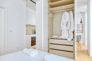 ein Schlafzimmer mit einem Schrank mit weißer Kleidung in der Unterkunft InLoveApartments - Luxury in Alfama in Lissabon + 252 Fotos