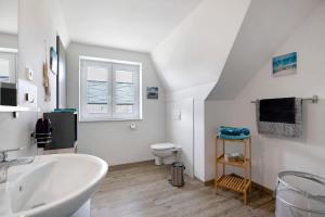 un bagno bianco con lavandino e WC di Ferienwohnung Windrose a Waldhusen Altre 17 foto