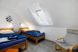 una camera con due letti e una sedia e una finestra di Ferienwohnung Windrose a Waldhusen