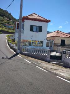 ein weißes Haus am Straßenrand in der Unterkunft Casa Gama in Ribeira da Janela + 10 Fotos