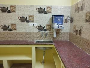cocina con fregadero y dispensador de jabón en la pared en Villa Eden 1bhk, en Pondicherry