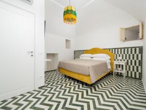 ein Schlafzimmer mit einem Bett und einem geometrischen Teppich in der Unterkunft Honey Home - De Vivo Realty Positano in Positano