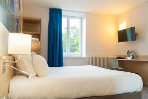 a hotel room with a bed and a window at Brit Hotel M&acirc;con Centre Gare in M&acirc;con