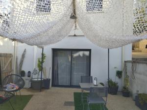a patio with a table and chairs under a curtain at Studio à Bellegarde in Bellegarde
