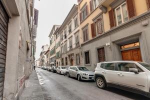 a row of cars parked on the side of a street at Mamo Florence - Fiesolana Apartments in Florence