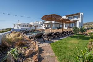 a patio with tables and chairs and umbrellas at Skyros Trias in Skiros