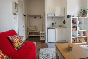 un soggiorno con un divano rosso e una cucina di Le petit cosy ad Angers