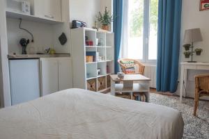una camera da letto con un letto, un tavolo e una finestra di Le petit cosy ad Angers