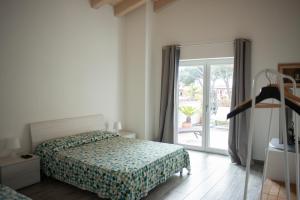 a bedroom with a bed and a sliding glass door at Dama casa vacanze in Marina di Campo