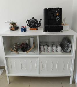 a white shelf with a coffee maker and a microwave at Vila Aqua in Eforie Sud