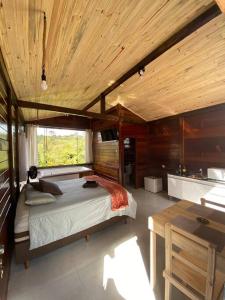 a bedroom with a bed and a wooden ceiling at Encanto da Mata - Chalé Ipê - Lavras Novas-MG in Lavras Novas