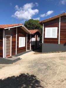 a couple of buildings with white shutters on them at Encanto da Mata - Chalé Ipê - Lavras Novas-MG in Lavras Novas