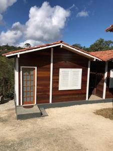 a small house with a door and a window at Encanto da Mata - Chalé Ipê - Lavras Novas-MG in Lavras Novas