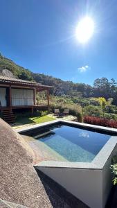 a swimming pool in front of a house at Villa Zarandi - Luxo e conforto que você procura! in Petrópolis