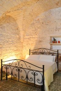 a bedroom with a bed in a stone wall at Casa Philos in Ceglie Messapica +22 photos