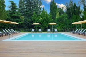 a swimming pool with chairs and umbrellas at Belstay Venezia Mestre in Marghera