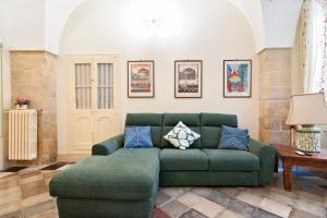 a living room with a green couch and a table at Corte del Fanfulla - Lecce Selection in Lecce