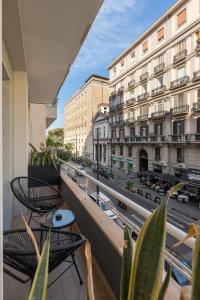 那不勒斯Le Mummarelle的阳台配有桌椅,享有街道的景色。