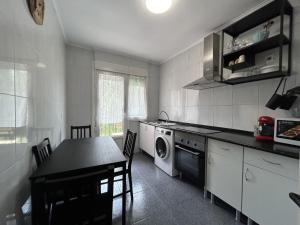 a kitchen with a table and a washing machine at Casa Mawi in Sopelana