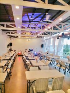 a banquet hall with white tables and chairs at Julia's Family Hotel & Events Place - DANGCAGAN, BUKIDNON , PHILIPPINES in Dancagan