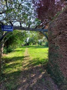 un cartello con la scritta Greenwich sotto un arco in un parco di Les roulottes de la Brauderie a Les Varennes