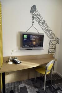 a desk with a television on top of it at ibis Styles Glasgow Centre George Square in Glasgow