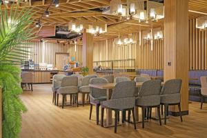 a row of chairs and tables in a waiting room at Friends Hotel Düsseldorf-Airport Ratingen in Ratingen