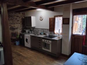 a kitchen with a sink and a stove top oven at Casa Marcelo in Proaza
