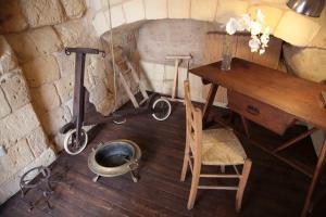 a room with a desk and a table and a bath tub at Fondo Vito in Gravina in Puglia
