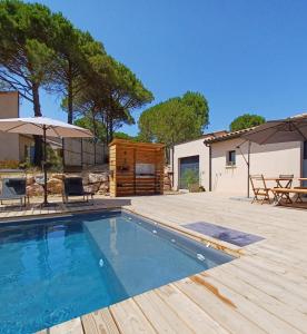 a swimming pool with a patio and a house at Villa MOUREZEVA in Mourèze