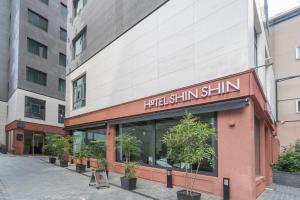 un edificio con un cartello che recita Nigel Shimlin Shine di Seoul Hotel ShinShin Myeongdong a Seul