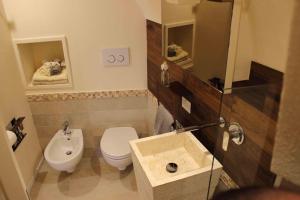 a small bathroom with a toilet and a sink at Fondo Vito in Gravina in Puglia