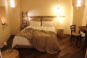 a bedroom with a large bed and a table at Fondo Vito in Gravina in Puglia