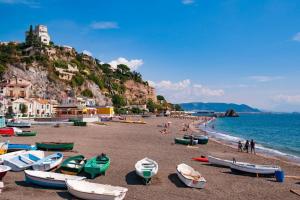 a beach with boats on the sand and the water at Ninfa Roda B&B in Vietri sul Mare