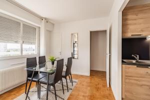 a dining room with a glass table and black chairs at T1 Confort Tête d'Or Doua - Parking Gratuit in Villeurbanne