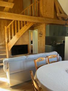 a living room with a couch and a staircase at Maison Lac du Der in Giffaumont-Champaubert