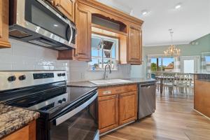 a kitchen with stainless steel appliances and wooden cabinets at Lagoon Luxury in Gulf Shores