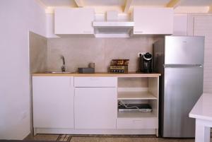 a kitchen with white cabinets and a white refrigerator at La Chicca in Grottaglie