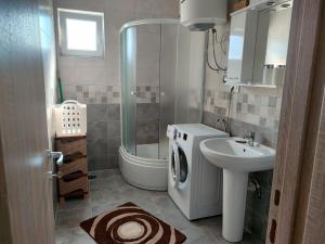 a bathroom with a sink and a washing machine at BOKI apartments in Bijela