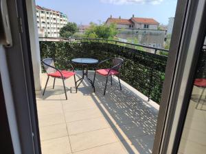 a balcony with two chairs and a table on a balcony at BOKI apartments in Bijela