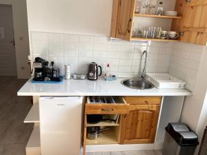 a small kitchen with a sink and a refrigerator at Fészek Apartmanház in Tapolca +20 photos