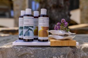 three bottles of oil sitting on a ledge with a plant at Modone Villas in Peloponnese in Methoni