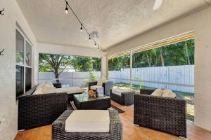 a living room with wicker chairs and a table at Hottub! Mini Golf! Water Access! Pets! 5min beach! in West Palm Beach