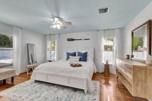 a white bedroom with a bed and a ceiling fan at Hottub! Mini Golf! Water Access! Pets! 5min beach! in West Palm Beach +49 photos