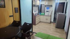 a small kitchen with a table and a refrigerator at Skyview Villa Udaipur with private pool 4Bhk Villa in Udaipur